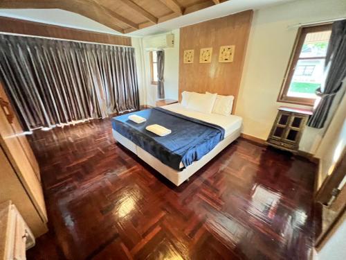 a bedroom with a bed and a wooden floor at Rockgarden Beach Resort in Mae Pim