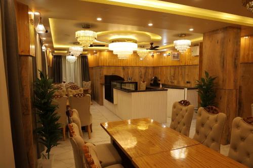 a dining room with a wooden table and chairs at Hotel M Sarthak Dehradun in Dehradun