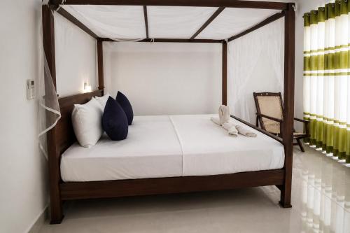 a bedroom with a canopy bed with a teddy bear on it at Butterfly Homestead Hotel in Udawalawe