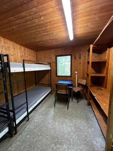 a room with two bunk beds and a table in it at Basecamp Brno in Brno