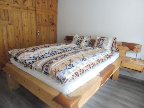 a large bed with a wooden frame in a room at Apartment Theresli First Floor in Saas-Almagell