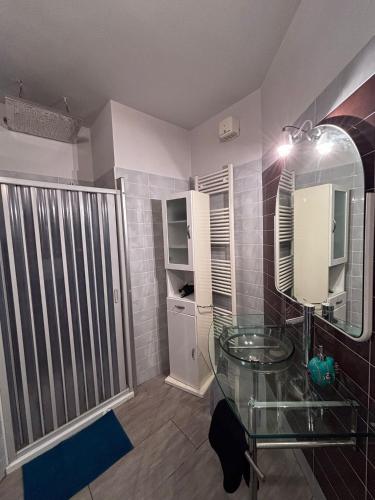 a bathroom with a glass table and a mirror at Le colline in corso Bra in Alba
