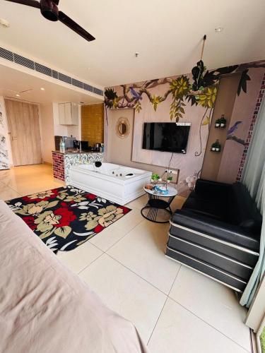 a large living room with a television and a bed at Nature Escape Jacuzzi Apartment in Gurgaon