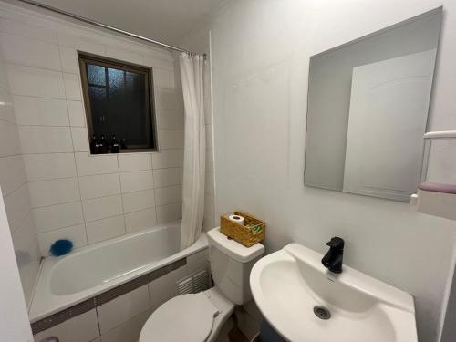 a bathroom with a white toilet and a sink at Casa cerca del Aeropuerto - Tu Espacio RE in Santiago
