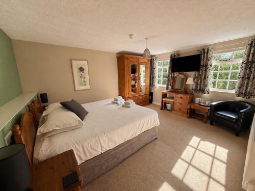 a bedroom with a bed and a desk and a chair at The Riverside in Boscastle
