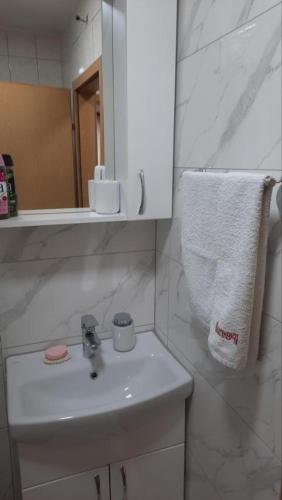 a bathroom with a sink and a mirror and a towel at Studio apartman City Centre Rogatica in Rogatica