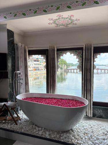 ウダイプールにあるHide-In Udaipur - A Lake View Boutique hotelの窓のある部屋に赤い花でいっぱいの大きな浴槽