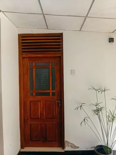 a wooden door in a room with a potted plant at kuma holiday resort in Meda-Ela