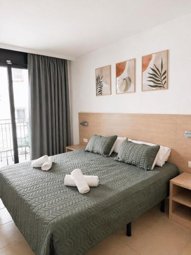 a bedroom with a large bed with two towels on it at Costa Suite Beach, Pool and Parking in Lloret de Mar