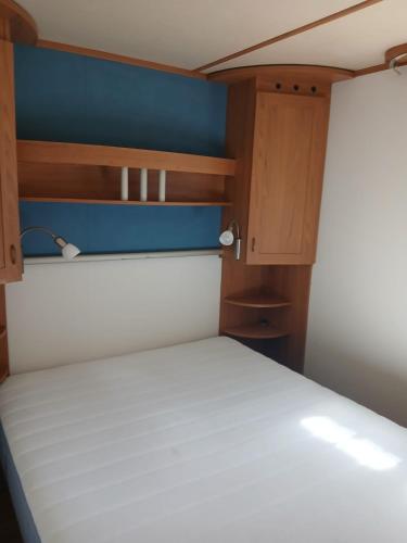 a small bedroom with a bed and wooden cabinets at Sosnowa Polana in Lipinki