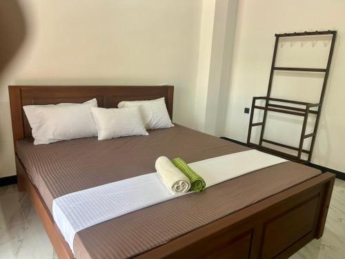 a bed with two towels and a ladder in a room at Wagon Inns anuradhapura in Anuradhapura