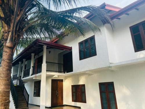a house with a palm tree in front of it at Wagon Inns anuradhapura in Anuradhapura