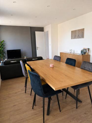 a dining room with a wooden table and chairs at L'entracte in Clairvaux-les-Lacs