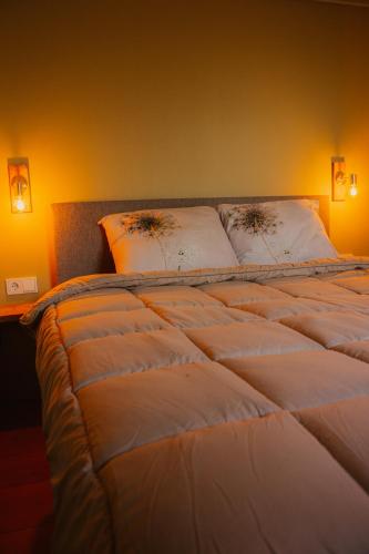 a large white bed with two pillows on it at B&B de Lytse Geast in Tietjerk