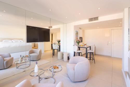 a living room with white furniture and a flat screen tv at Le Semiramis l Central & Views l Shellter Rentals in Saint-Tropez