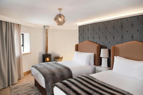 a hotel room with two beds and a fireplace at Sani Mountain Escape in Mokhotlong