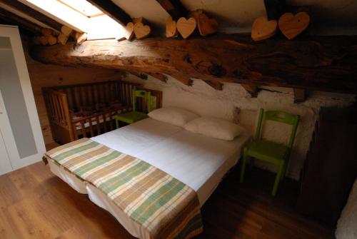 - une chambre mansardée avec un lit et une chaise dans l'établissement Country Villa Altare, à Altare