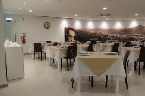 a dining room with white tables and black chairs at Hotel José Régio in Portalegre