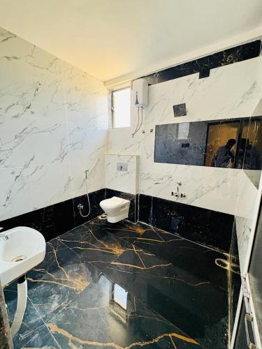 a bathroom with a toilet and a sink at Hotel Siyaram Inn in Trimbak