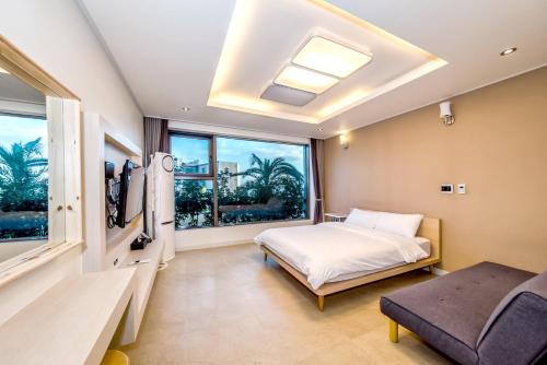 a bedroom with a bed and a window at Donnaekohill Resort in Seogwipo