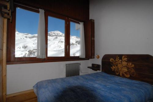ブレウイル・チェルヴィナイアにあるLa Coquille Apartmentの雪に覆われた山の景色を望むベッドルーム