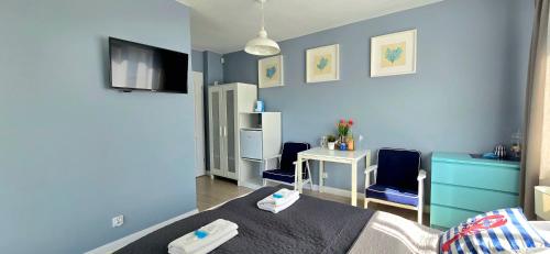 a bedroom with blue walls and a bed and a desk at Pokoje Syrenka by TriApart in Stegna