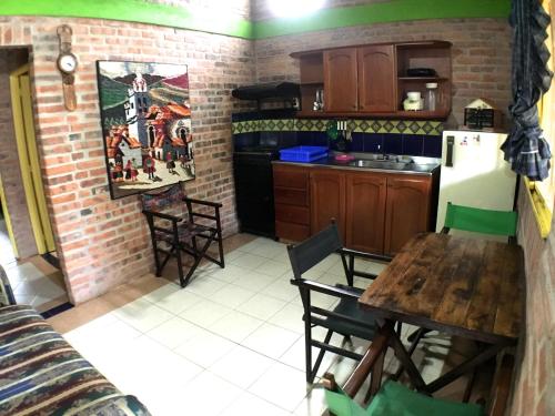 a kitchen with a table and a refrigerator at Cabañas La Carolina - Mesa de Los Santos in Los Santos