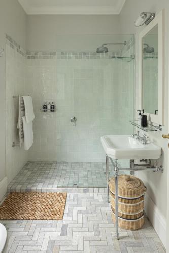a white bathroom with a sink and a shower at Vivere in Hermanus