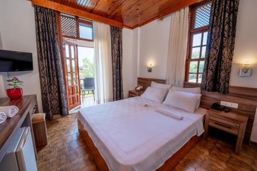 a bedroom with a large white bed with windows at Palma Rosa Hotel in Kemer