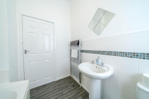 a white bathroom with a sink and a toilet at 3 Bedroom House in Rishton by Eason Stays, Great Location Near Shops & Transport in Rishton