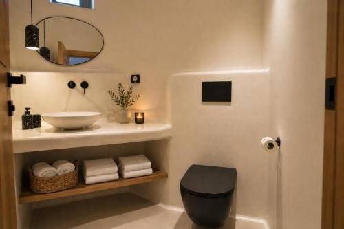 a bathroom with a sink and a mirror at Panthea Suite Santorini - Private pool in Vourvoúlos