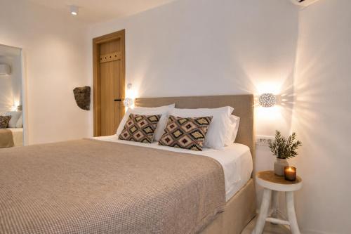 a bedroom with a bed and a table with a lamp at Panthea Suite Santorini - Private pool in Vourvoúlos