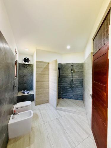 a bathroom with a shower and a toilet and a sink at Sky Palace Hikka in Hikkaduwa