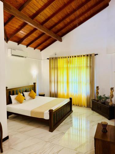 a bedroom with a large bed and a wooden ceiling at Sky Palace Hikka in Hikkaduwa