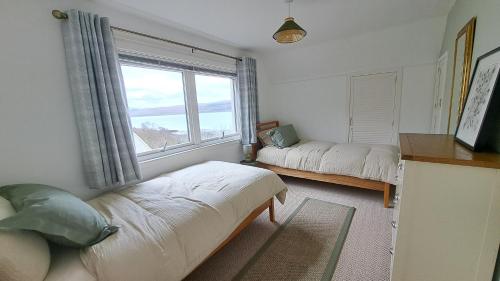 a bedroom with two beds and a large window at Seaview Cottage, Drimnin in Drimnin