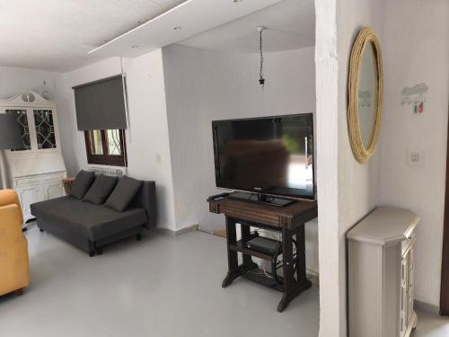 a living room with a flat screen tv and a couch at Villa Cayetana in Jávea