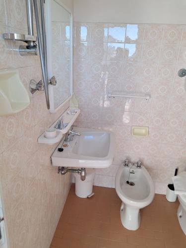 a bathroom with a sink and a toilet and a mirror at Hotel Adriatico in Bellaria-Igea Marina