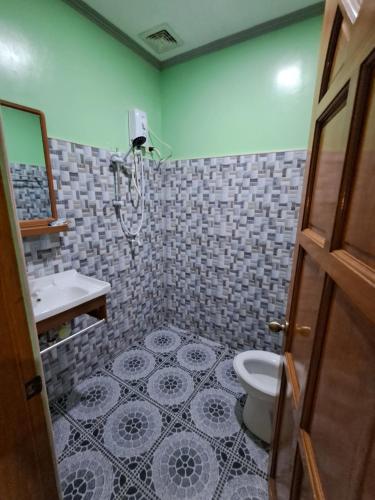 a bathroom with a toilet and a sink at JMM Guest House in Panglao Island