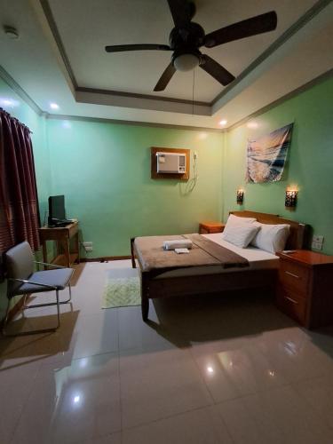 a bedroom with a bed and a ceiling fan at JMM Guest House in Panglao Island