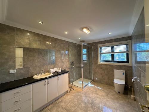 a bathroom with a sink and a shower and a toilet at Shine House in Balwyn North