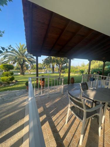 a patio with a table and chairs under a roof at Barbara House in Kriopigi