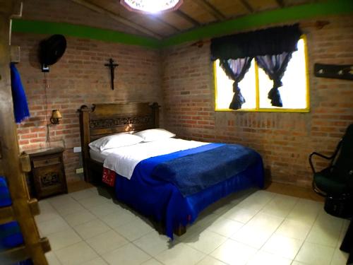 a bedroom with a bed in a brick wall at Cabañas La Carolina - Mesa de Los Santos in Los Santos