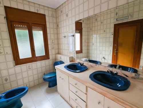 a bathroom with two sinks and a blue toilet at Urmi 8 Vista Mar in Peniscola