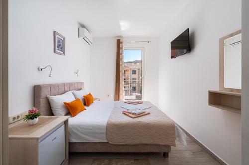 a bedroom with a bed with orange pillows and a window at Villa Ines in Budva