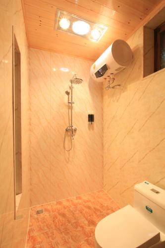 a bathroom with a shower and a toilet at The Great Wall Courtyard Hostel in Yanqing