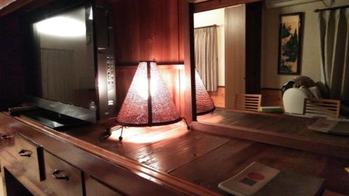 a room with a mirror and a lamp on a table at Minpaku Nambu in Koka