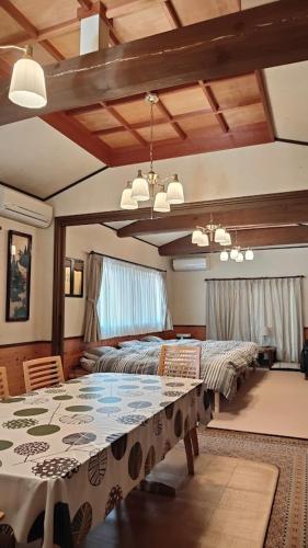 a bedroom with a bed and a table in it at Minpaku Nambu in Koka