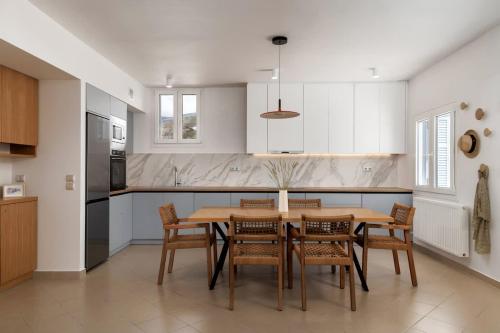 a kitchen with a dining room table and chairs at Stunning View Sarakiniko Villa in Agios Petros