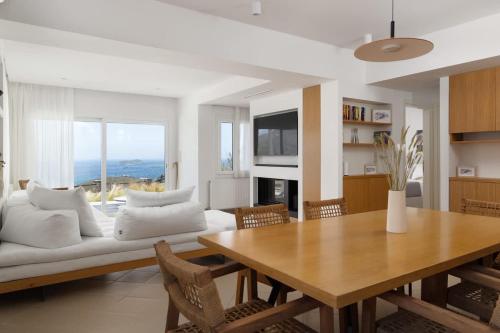 a living room with a white couch and a table at Stunning View Sarakiniko Villa in Agios Petros