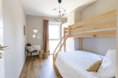 a bedroom with a bunk bed and a chair at "Lac'Almie" - Appartement 2 chambres avec Terrasse et Parking in Doussard